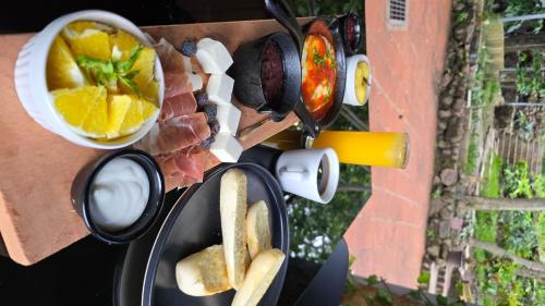 un barbecue avec de la viande et du pain et un bol de fruits dans l'établissement Bosko cerro verde, à Lomas de San Marcelino