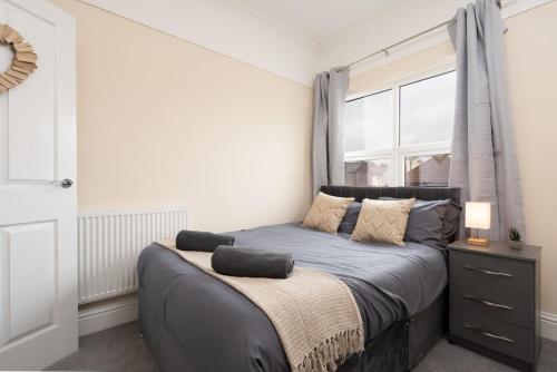 a bedroom with a bed with a window at Large cosy house - free on street parking in Liverpool