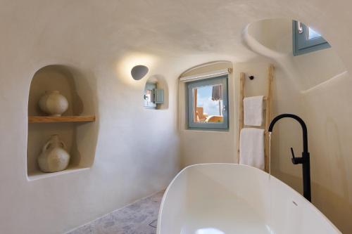 a bathroom with a white toilet and a window at Annouso Villa with Hot Tub by Caldera Houses in Oia