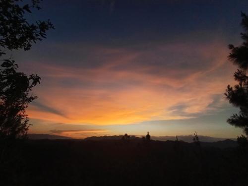 a sunset over the mountains with a person in the foreground at Paraiso Verde in Chijoú