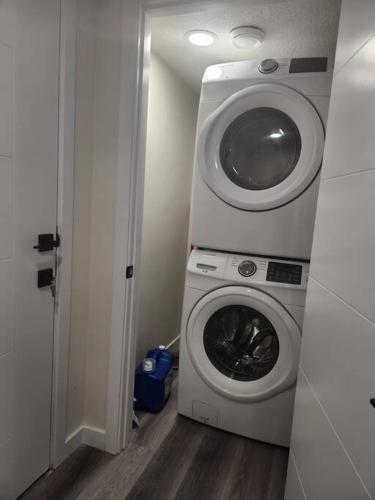 a washer and dryer in a small room at Modern 2 Bedroom Basement Suite Chappelle Edmonton in Edmonton