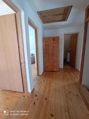 an empty room with wooden floors and doors at Druga priča in Vlasic