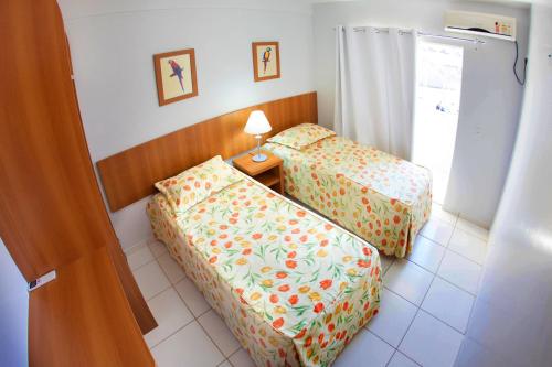 a hotel room with two beds and a lamp at Golden Dolphin Grand Hotel via Giro ImobTech in Caldas Novas