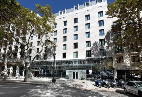 a large white building with motorcycles parked in front of it at Eurostars Das Letras in Lisbon