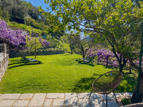a park with benches and trees with purple flowers at La Casa dei Glicini in Levanto