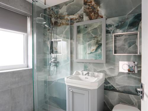 a bathroom with a sink and a shower at Seaside Sanctuary in Holyhead