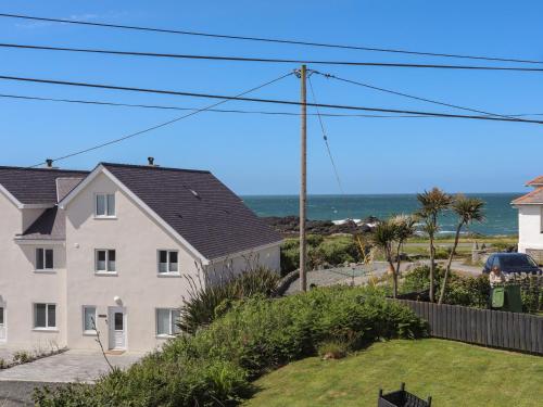 a white house with the ocean in the background at Seaside Sanctuary in Holyhead