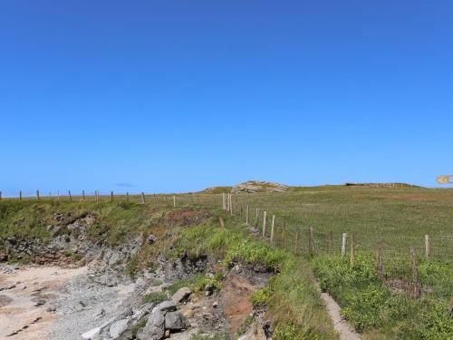 a fence on the side of a grass field at Seaside Sanctuary in Holyhead