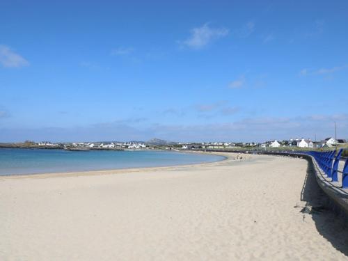 a view of a beach with a blue fence at Seaside Sanctuary in Holyhead