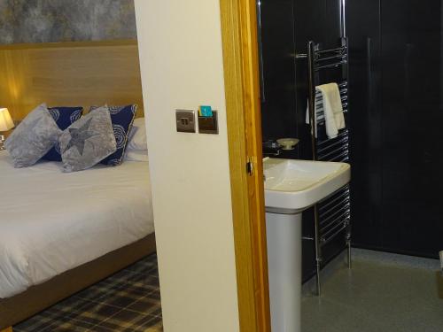a bathroom with a sink next to a bed at Oddfellows Hotel in Carlton