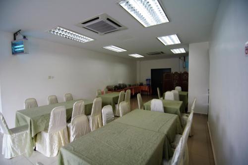 una sala de conferencias con mesas, sillas y tragaluces en T Hotel Changlun, en Changlun