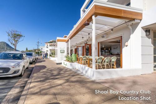 a street with a car parked next to a building at The Beach Shack 28 Shoal Bay Road fantastic original beach house that allows pets in Shoal Bay