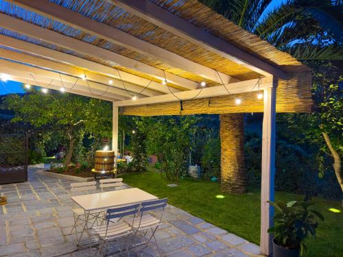 a patio with a table and chairs under a pergola at La Casa dei Glicini in Levanto