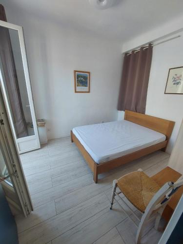 une chambre avec un lit, une fenêtre et une chaise dans l'établissement Nice Charmant 2 pièces, à Nice