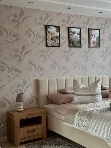 a bedroom with a bed and a wall with wallpaper at Pokoje Gościnne U ANI in Głogówek