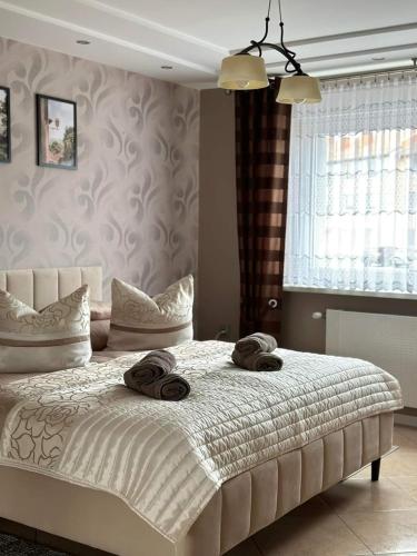 a bedroom with a bed with two towels on it at Pokoje Gościnne U ANI in Głogówek