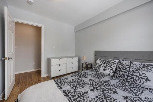 a bedroom with a black and white bed and a dresser at 3 bedroom appartment-limestone in Kingston