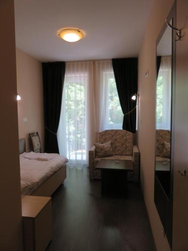 a bedroom with a bed and a chair and a window at Bartal Rodinné Vinárstvo in Šamorín