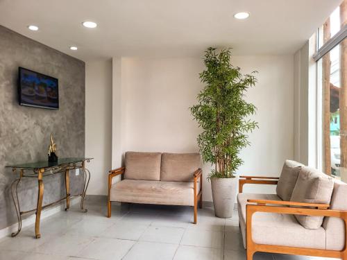 a living room with a couch and a table and a plant at Atlântico Sul Hotel in Porto De Galinhas