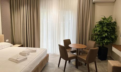 a hotel room with a bed and a table and chairs at Anchor Luxury Rooms in Vlorë
