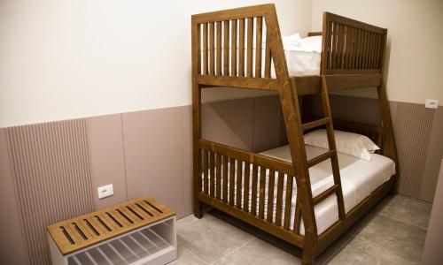 a wooden bunk bed in a room with a bench at Anchor Luxury Rooms in Vlorë