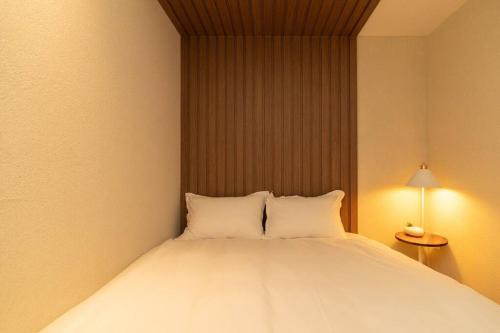 a bed with two pillows in a room at The First Gwangan in Busan
