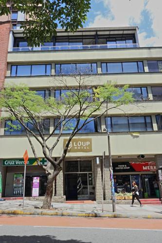 a man walking down a street in front of a building at Hotel Loup in Medellín