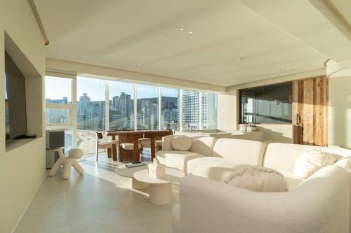 a living room with white furniture and a large window at The First Gwangan in Busan
