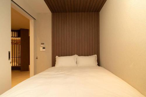 a bed with two pillows in a room at The First Gwangan in Busan