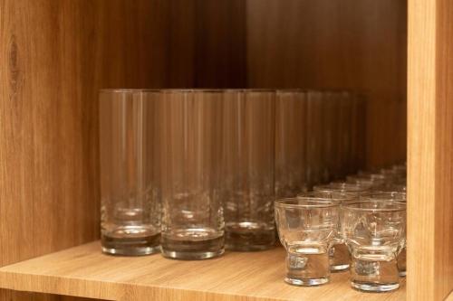 a row of glasses sitting on a wooden shelf at The First Gwangan in Busan