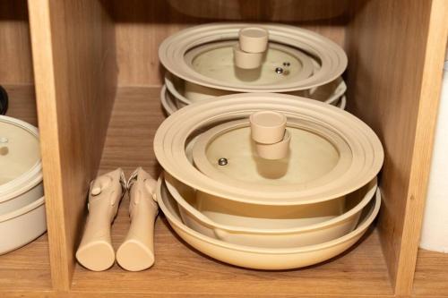 a group of plates and pans in a cabinet at The First Gwangan in Busan