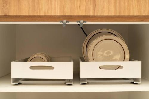 two white cabinets with plates and bowls on them at The First Gwangan in Busan