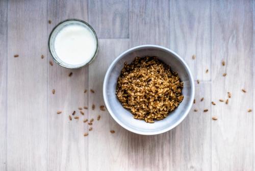 eine Schüssel Haferflocken und ein Glas Milch auf einem Holztisch in der Unterkunft Skylight Room! in Lucan