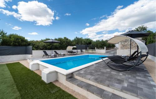 una piscina con sillas y una sombrilla en un patio en Gorgeous Home In Polaca, en Polača