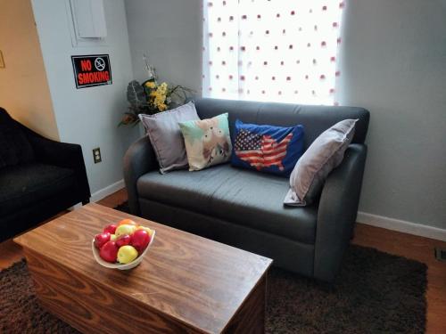 a living room with a couch and a table with a bowl of fruit at Stylish and Beautiful Condo in Frederick