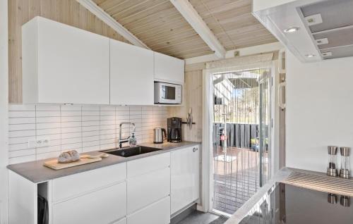a kitchen with white cabinets and a sink at Holiday Home Kragevej in Hirtshals
