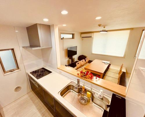 a kitchen with a sink and a dining room at Convertel Honhaneda by Tranova in Tokyo