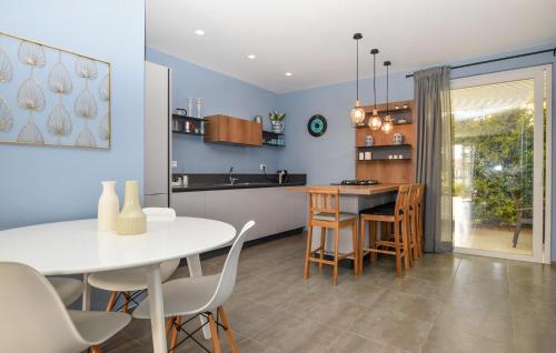 eine Küche und ein Esszimmer mit einem weißen Tisch und Stühlen in der Unterkunft Cozy Home In Marina Di Ragusa With Wifi in Marina di Ragusa