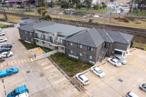 a large building with cars parked in a parking lot at Value Suites Penrith in Penrith
