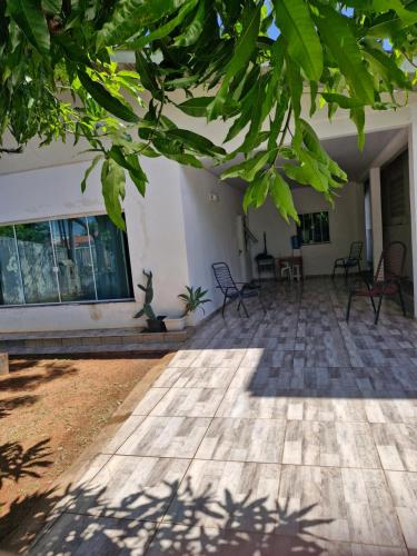 a courtyard of a house with chairs and trees at Casa Cataratas in Foz do Iguaçu
