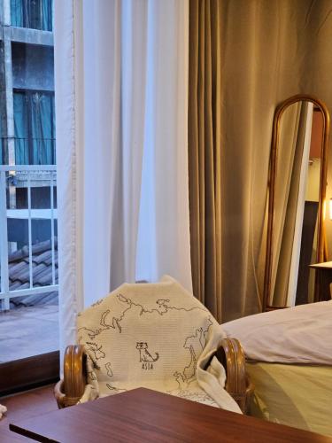 a chair with a pillow on it in front of a window at 88 Fine Hotel @ Suratthani Airport in Surat Thani
