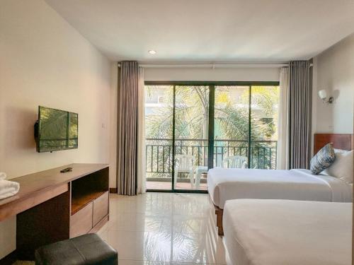 a hotel room with two beds and a balcony at XAYA Pool Access Resort - Phuket in Phuket