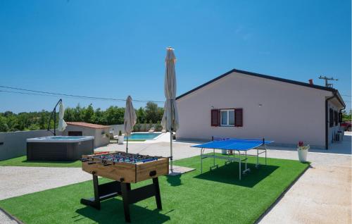 a backyard with a ping pong table and a pool at Awesome Home In Mali Vareski in Mali Vareški