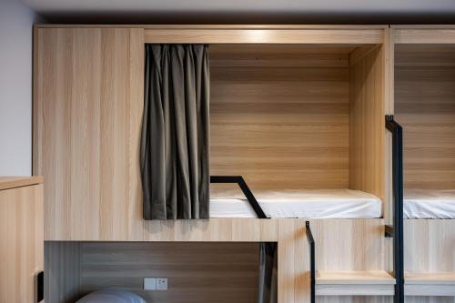 two bunk beds in a room with wooden cabinets at Dayin Youth Hostel - Old Town & People's Square& Rail Hub -Social Area -Bar -Café -Gym -Free Laundry Luggage Storage -24H Front Desk -English Service in Shanghai