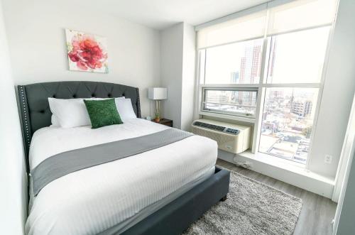新罗谢尔Apt Close to Downtown with Gym的一间带床和大窗户的卧室