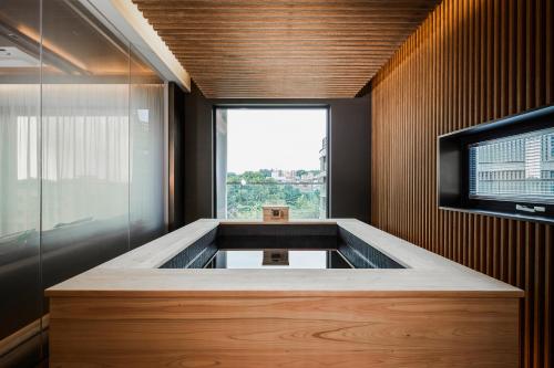 a large bath tub in a room with a window at ANTO, Formerly Paraspara Seoul in Seoul