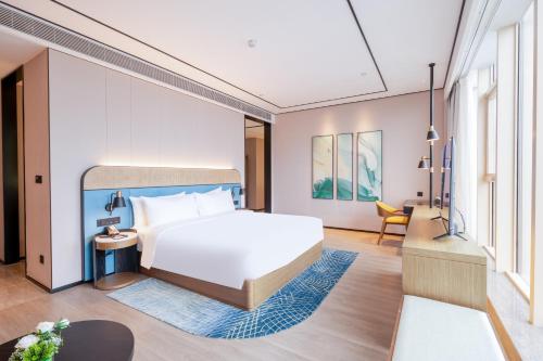 a bedroom with a bed and a living room at Hilton Garden Inn Hangzhou Xixi Zijingang in Hangzhou