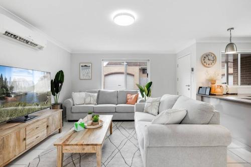 a living room with a couch and a tv at Stones throw to Grammar, Queens Park & CDB! in Toowoomba