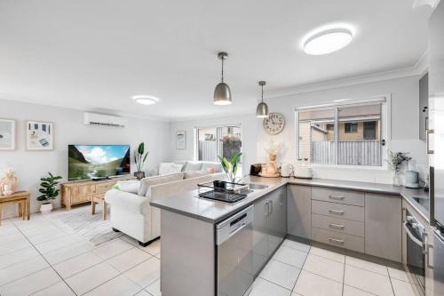 a kitchen and living room with a couch and a table at Stones throw to Grammar, Queens Park & CDB! in Toowoomba
