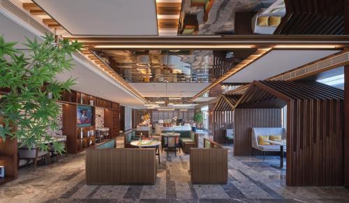 a lobby of a restaurant with tables and chairs at Hilton Garden Inn Hangzhou Xixi Zijingang in Hangzhou